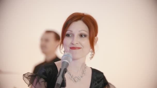 Музыкальная группа играет песню - взрослая рыжая женщина поет — стоковое видео