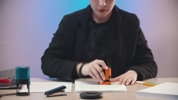 Γραφείο - μια νεαρή γυναίκα βάζει σφραγίδα στα έγγραφα — Αρχείο Βίντεο