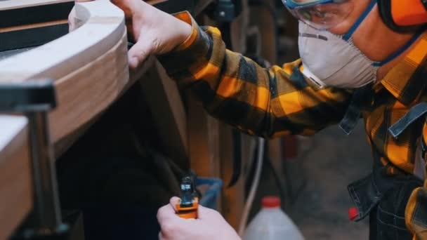 Carpentry industry - a man woodworker measuring the detail width for the next processing — Stockvideo