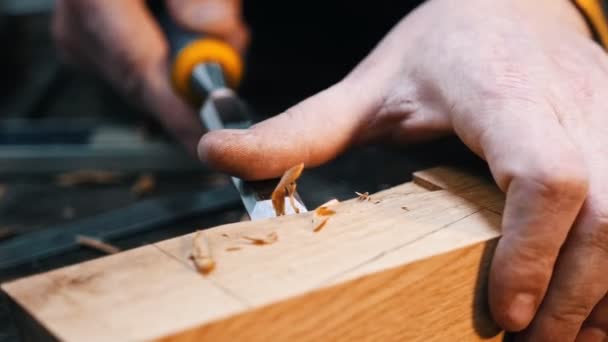 Tischlerei - ein Holzarbeiter schneidet mit einem Meißel und seinen Händen die Aussparung des Holzdetails aus — Stockvideo