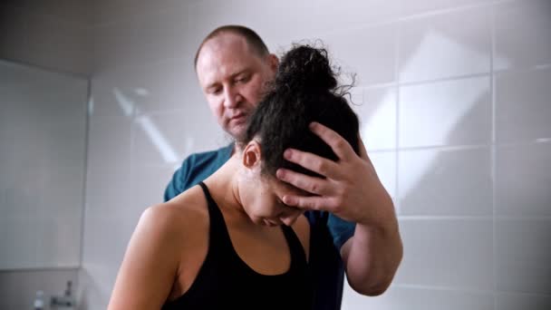 Chiropractic treatment - the doctor bending the young womans neck up and down — Stockvideo