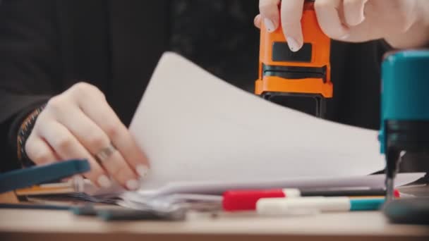 Kancelář - žena razítkuje dokumenty jeden po druhém — Stock video