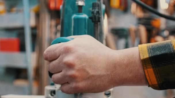 Industria de la carpintería: un carpintero pule el lado del detalle de madera en un taller — Vídeo de stock