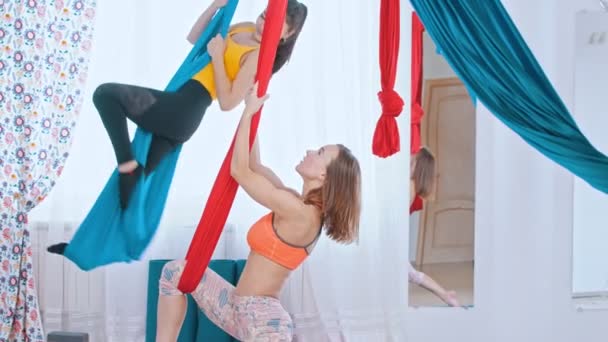 Letecká jóga - dvě atletky, které mají trénink ve světlém studiu — Stock video