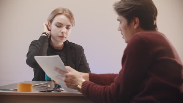 Bureau - un homme dit ce qu'il y a sur les documents et la fille écoute — Video