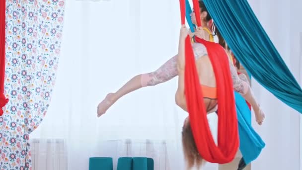 Воздушная йога - две спортсменки, тренирующиеся в светлой просторной студии — стоковое видео