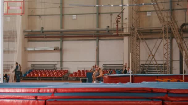 Stabhochsprung - junge Sportlerin rennt und springt über die Latte — Stockvideo