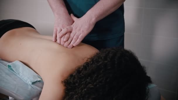 Хиропрактика - врач готовит женскую шею к массажу — стоковое видео