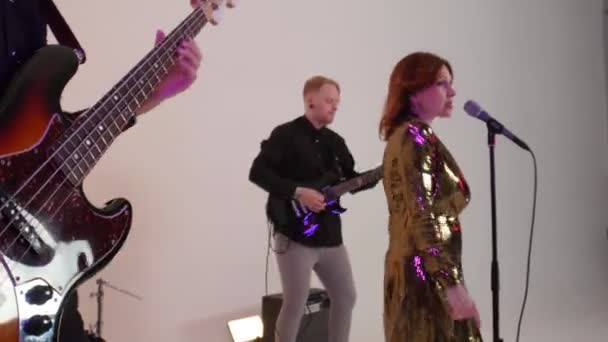 Музыкальная группа людей в костюмах на сцене играет песню в студии — стоковое видео