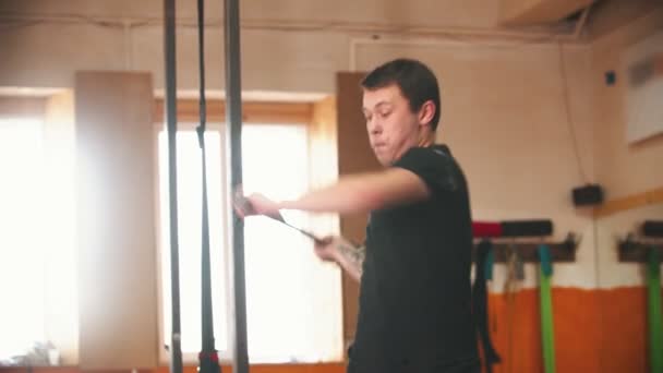 Een man slaat een grote band met een metalen hamer in de sportschool — Stockvideo