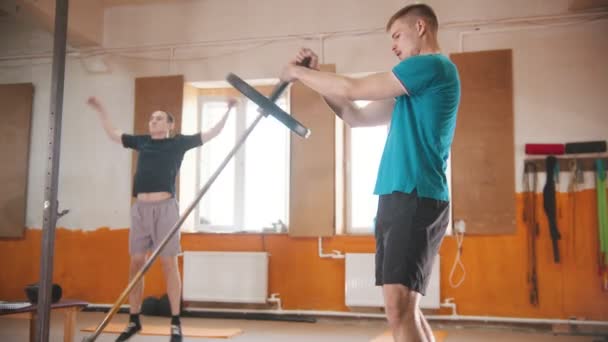 Hombres entrenando en el pequeño gimnasio - un hombre saltando - un hombre entrenando sus manos — Vídeos de Stock