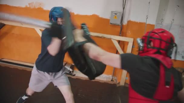 Två män riddare som har en träning kamp i gymmet med hjälp av ett säkert svärd och sköld — Stockvideo