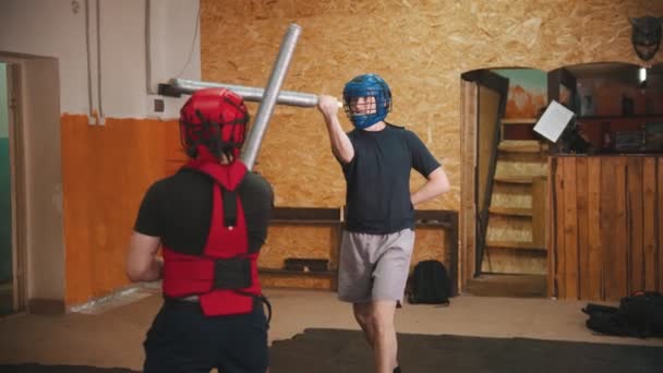 Deux hommes chevaliers ayant un combat d'entraînement dans la salle de gym à l'aide d'une épée sûre — Video