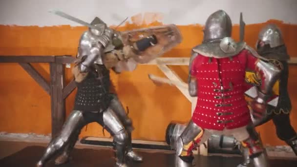 Quatre hommes chevaliers ayant un combat d'entraînement à l'intérieur 