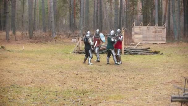 Quatre hommes chevaliers se battent sur le terrain au milieu de la forêt — Video