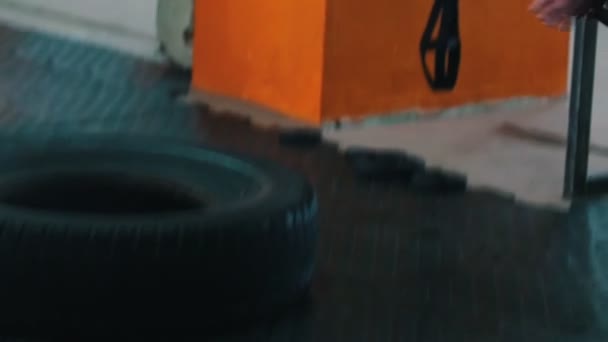 Treinamento esportivo - um homem atlético tatuado batendo um pneu grande com um martelo de metal — Vídeo de Stock