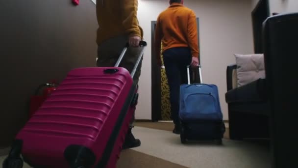 En familj som kommer in i ett hotellrum - drar sitt bagage efter sig — Stockvideo