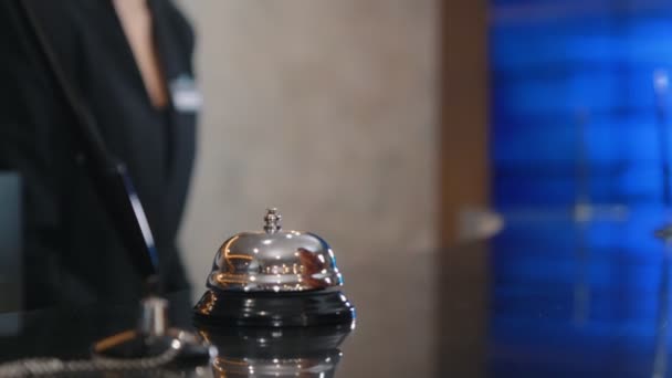 Kobieta w kostiumie dzwoni dzwonkiem na stół. — Wideo stockowe