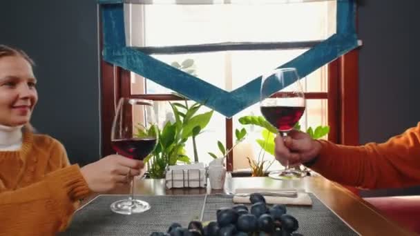 Rodzina siedząca w hotelowej restauracji - mężczyzna i kobieta brzęczący kieliszkami i pijący wino — Wideo stockowe
