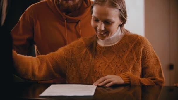 En familjekontroll på lyxhotellet - en leende kvinna som skriver på pappren — Stockvideo