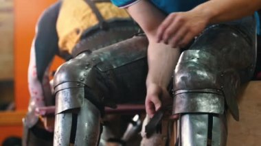 Şövalyeler antrenman yapıyor. Metal koruyucu bir zırh giyen bir adam.