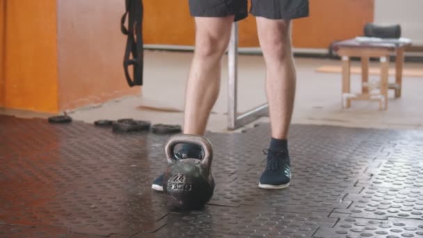 Sporttréning házon belül - az ember felveszi a súlyt a padlóról — Stock videók
