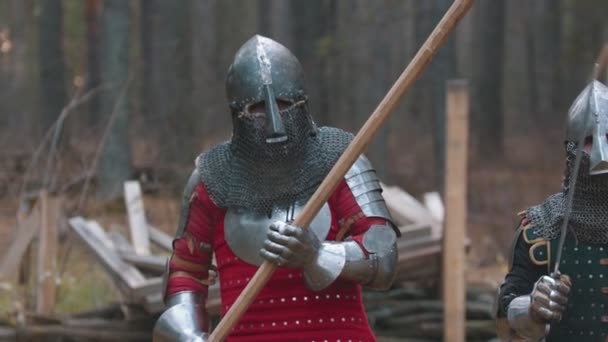 Рыцарь гуляет по лесу в полной броне с оружием в руках. — стоковое видео