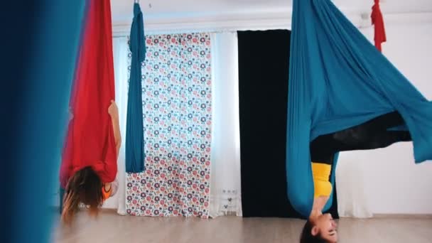 Aerial Yoga - zwei Frauen graben in Hängematten und hängen kopfüber — Stockvideo