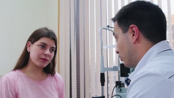 Tratamiento oftalmológico: mujer joven que consulta con un médico de optometría en el gabinete — Vídeos de Stock