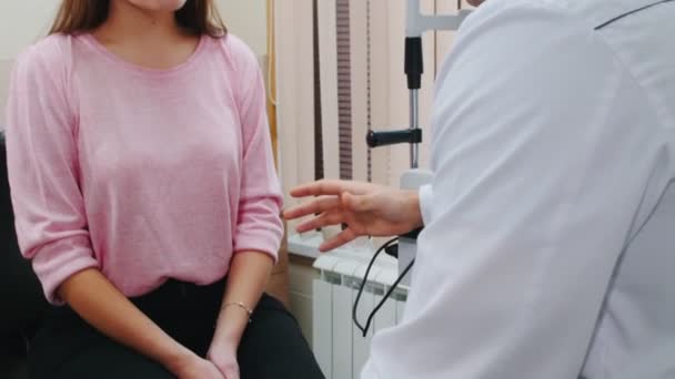 Oogheelkundige behandeling - jonge vrouw heeft een consult met een optometrie arts in het kabinet - luisteren naar wat de dokter zegt — Stockvideo