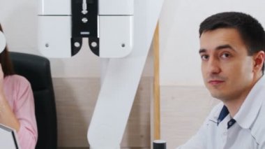 Göz ftalmolojisi tedavisi - görme keskinliğini kontrol eden genç bir kadın - bir göz kalkanıyla gözlerini kapatıyor ve okuyor
