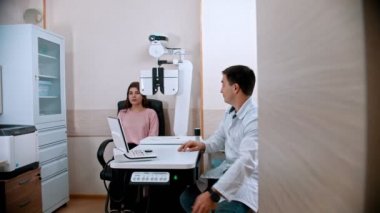 oftalmoloji tedavisi - genç bir kadın görme keskinliğini bir optometrist ile kontrol ediyor