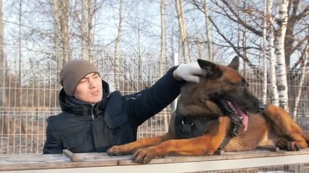 Bir köpek ve antrenörü oyun sahasında köpeği okşuyor. — Stok video