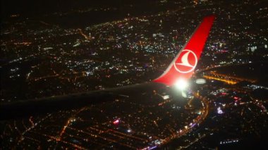 25-11-2019 Hollanda, Amsterdam: Şehrin gece lambaları üzerindeki uçak penceresinden bir manzara