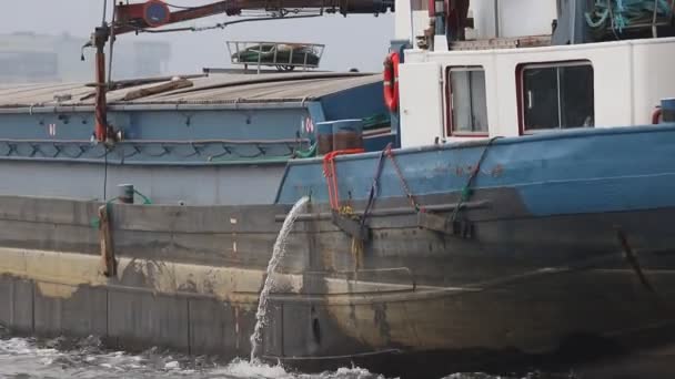 23-11-2019 Niederlande, Amsterdam: Ein Frachtkahn transportiert eine Ladung in den Hafen - dabei wird Wasser aus dem Schiff gelassen — Stockvideo
