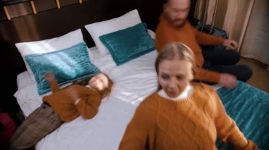 Yorgun ama mutlu bir aile otel yatağına düşüyor.