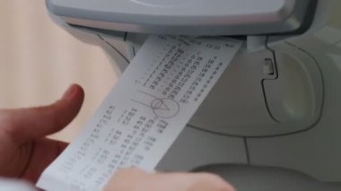 Ftalmoloji tedavisi - özel bir optometri ekipmanı - bir adam görsel keskinlik analizi sonucu makbuzu alır