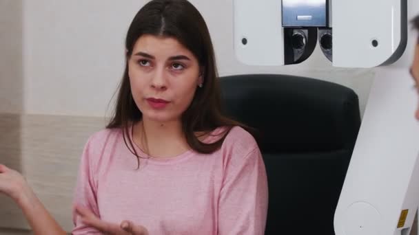 Tratamiento oftalmológico: mujer joven que habla con el médico sobre sus problemas con la agudeza visual — Vídeo de stock
