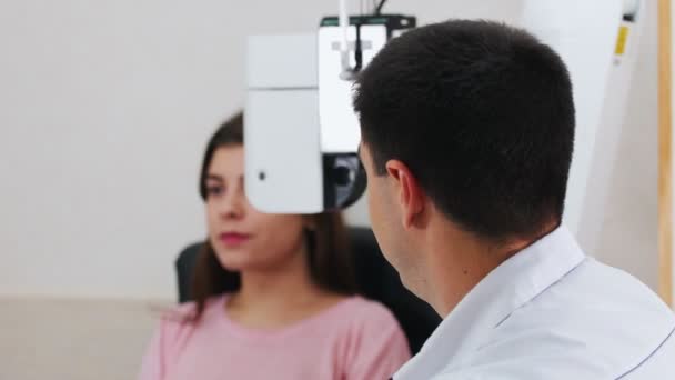 Oftalmoloji tedavisi - genç bir kadın görme keskinliğini özel büyük bir optometri makinesiyle kontrol ediyor — Stok video