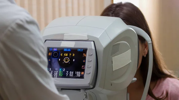 안과학 - 시각의 정확성을 검사하는 특수 장비를 가지고 일하는 의사 - 이 시력의 정확성을 분석하는 모습 — 스톡 사진