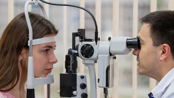 眼科治疗-年轻女子在明亮的橱柜里用特殊设备检查视力 — 图库照片