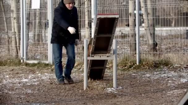 Entraînement de chien sur le terrain d'entraînement - Un chien de berger allemand qui court sur le double swing — Video