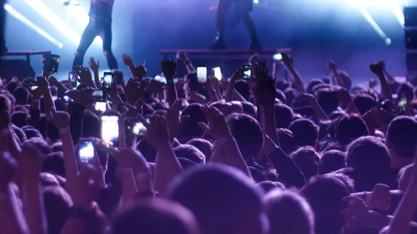 Des gens énergiques dansant les mains en l'air au concert — Photo