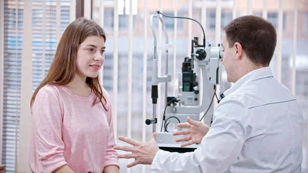 Tratamento oftalmológico no armário - jovem mulher sorridente tendo uma consulta com um médico de optometria — Fotografia de Stock