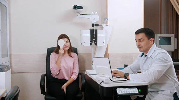 Augenarztbehandlung im Schrank - junge Frau überprüft ihre Sehschärfe - Augen mit Augenschutz verschließen — Stockfoto