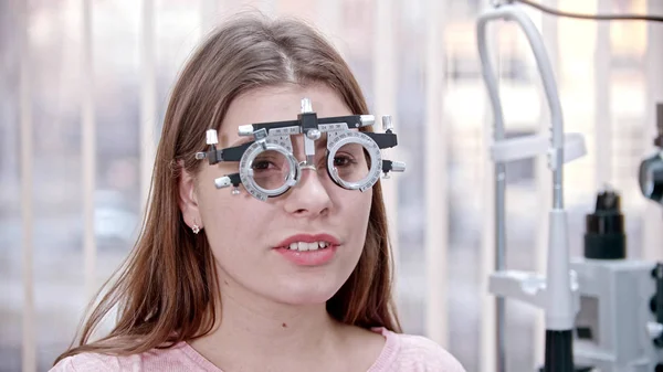 Ophtalmologie - une jeune femme avec un appareil pour le test de vision sur son nez — Photo