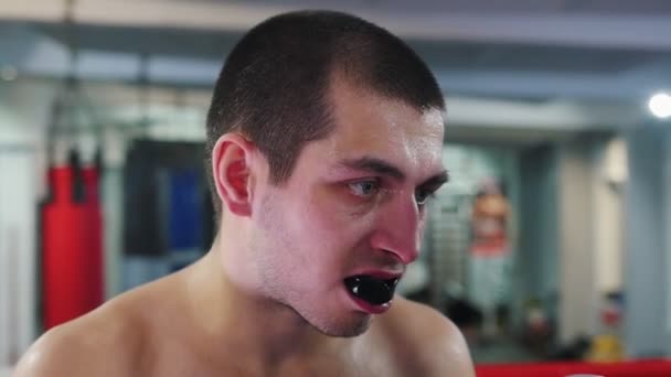 Boxtraining - ein Mann mit Mundschutz wird getroffen - der Wachmann fliegt aus dem Mund — Stockvideo