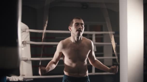 Trening bokserski - człowiek stojący na ringu i skaczący po skakance — Wideo stockowe