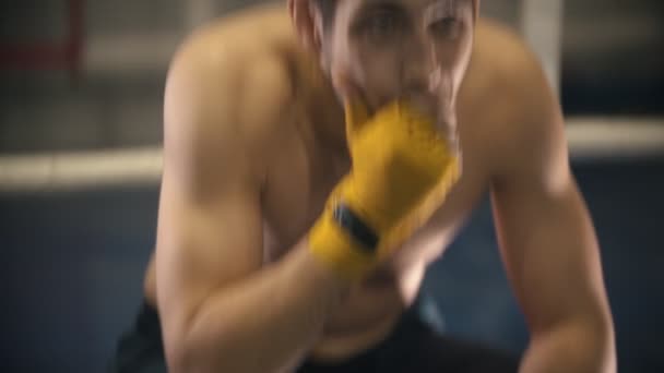 Тренировка по боксу - уставший человек сидит в углу ринга и отдыхает — стоковое видео