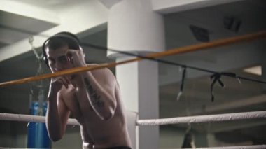 Box antrenmanı. Spor salonunda kulaklık takan bir adam. Gölge savaşı.